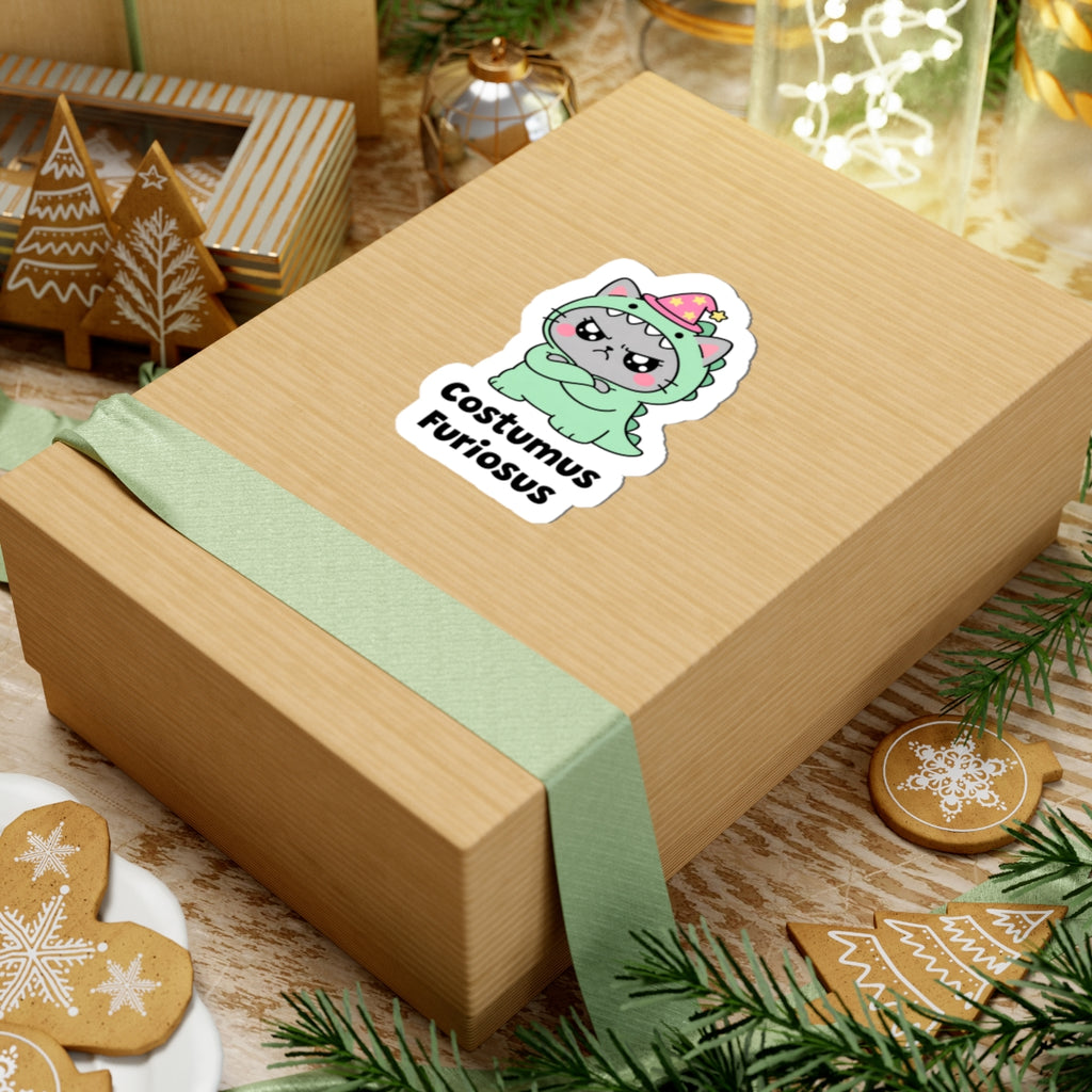 Costumus Furiosus wizard cat sticker on a kraft gift box with a green ribbon and holiday cookies