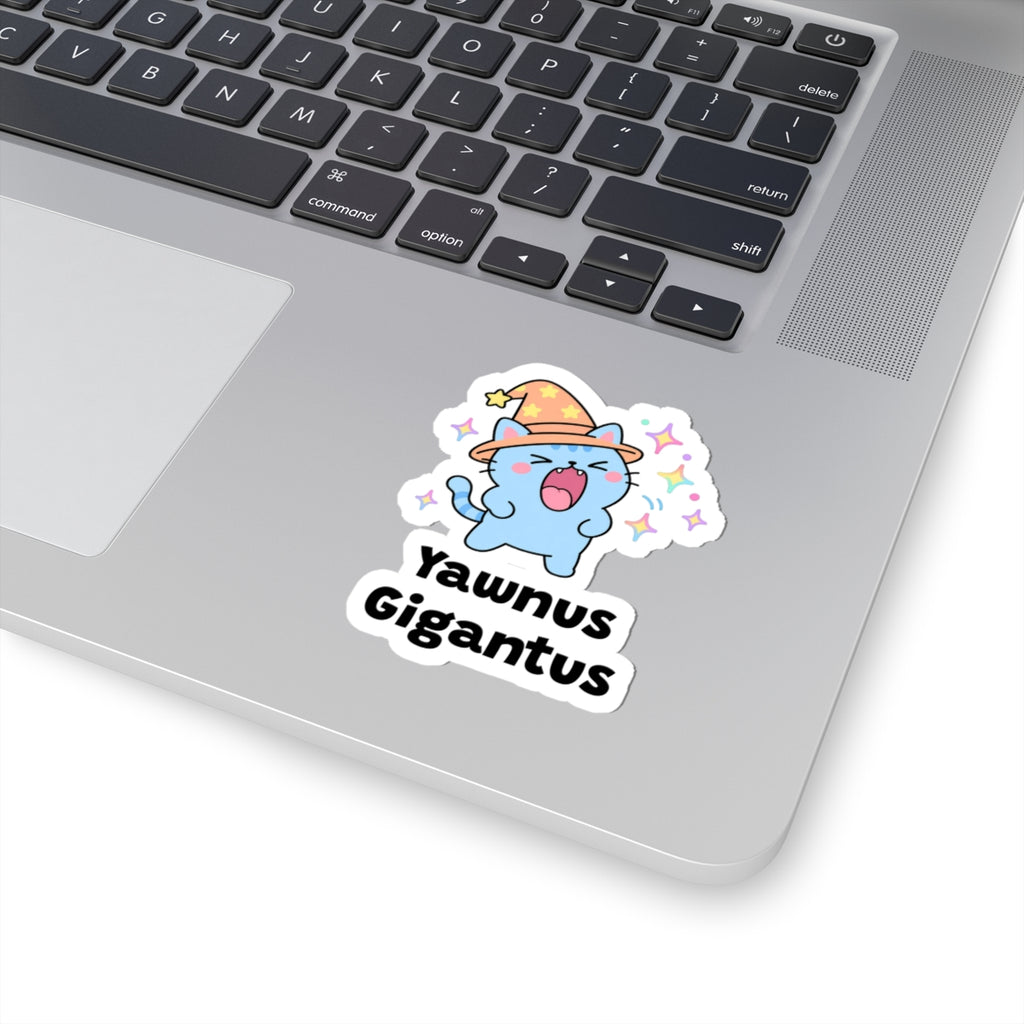 Yawnus Gigantus wizard cat sticker stuck on a silver laptop next to the keyboard