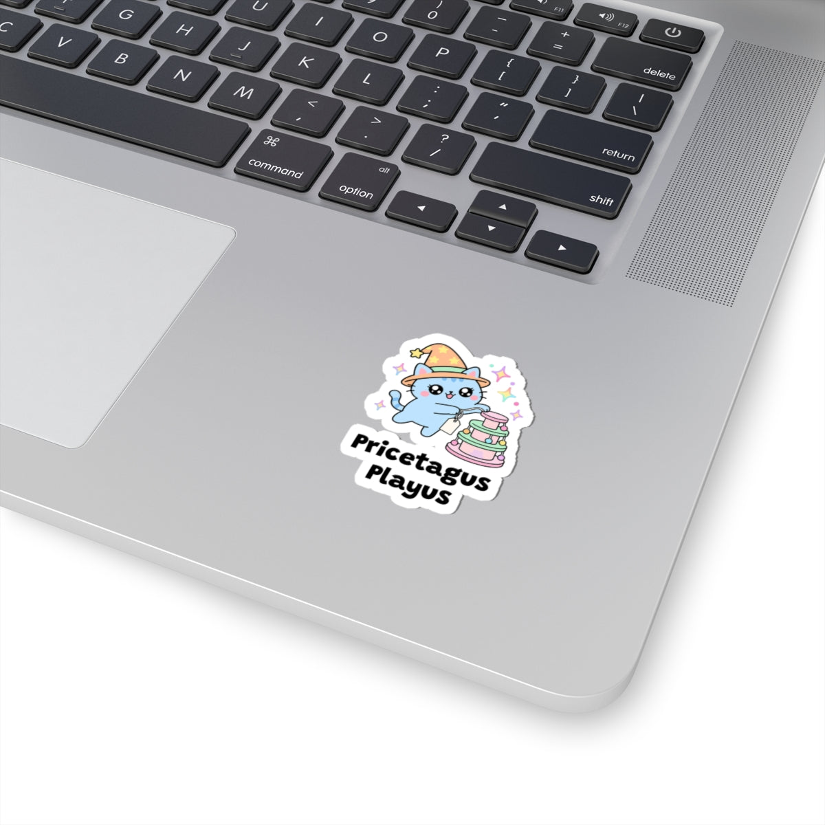 Pricetagus Playus wizard cat sticker stuck on a silver laptop next to the keyboard