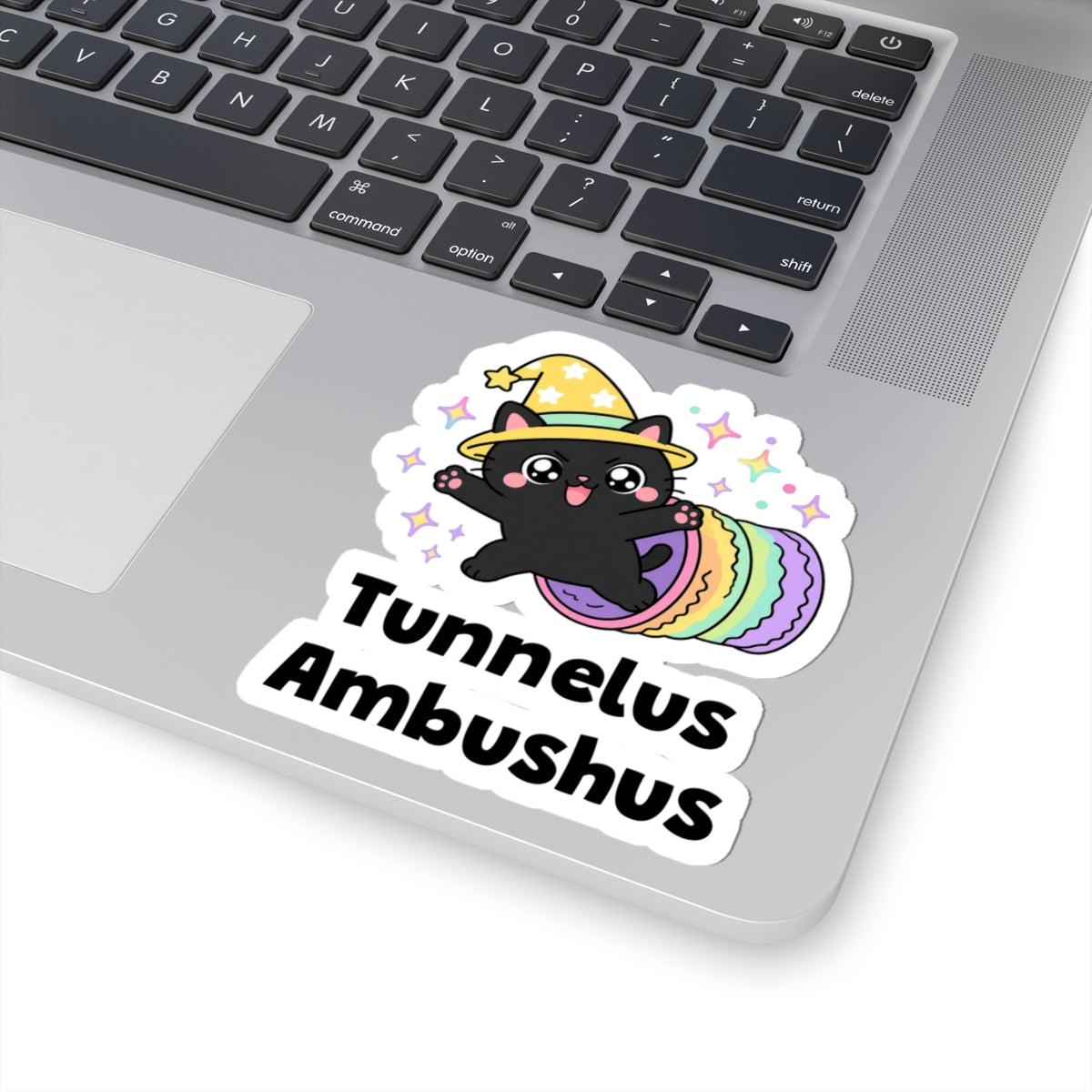 Tunnelus Ambushus wizard cat sticker stuck on a silver laptop next to the keyboard