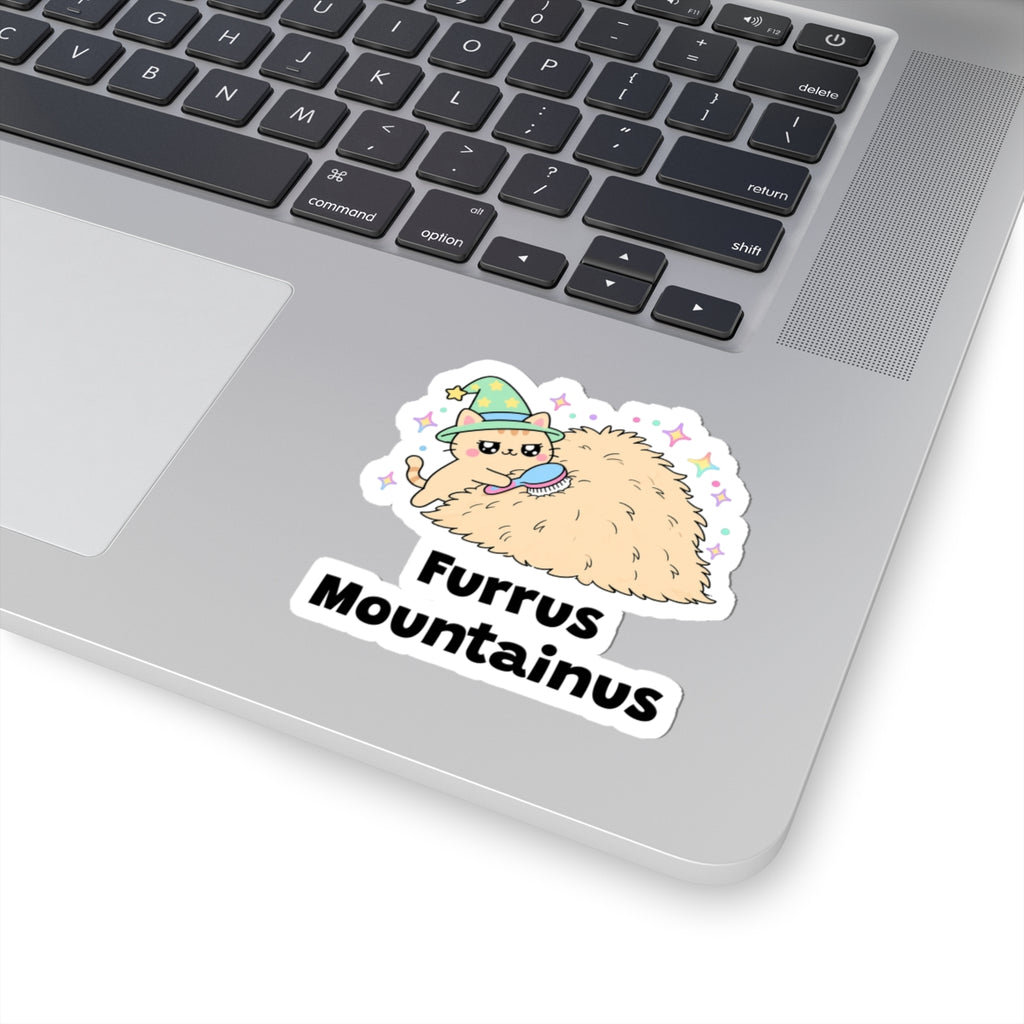 Furrus Mountainus wizard cat sticker stuck on a silver laptop next to the keyboard