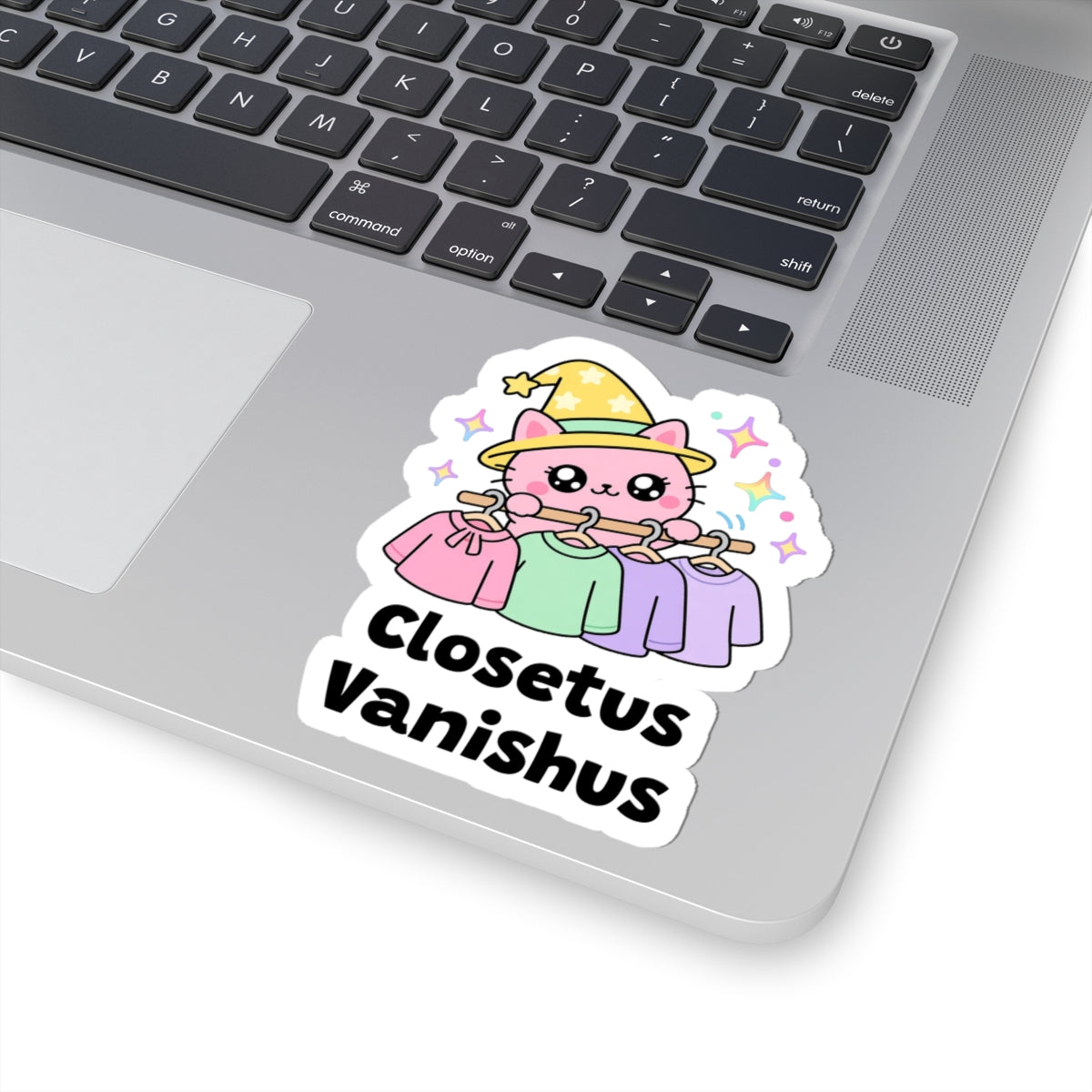 Closetus Vanishus wizard cat sticker stuck on a silver laptop next to the keyboard