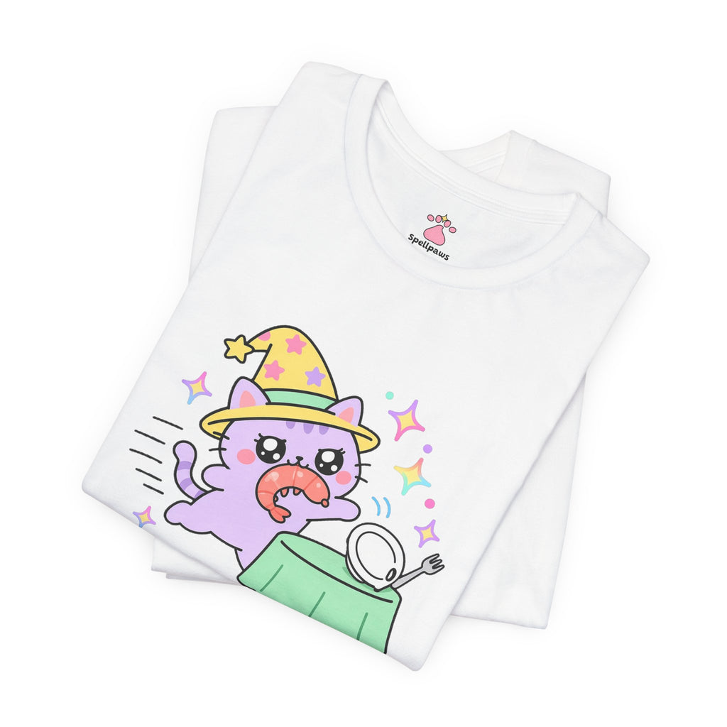 Folded white Shrimpus Snatchus T-shirt showing a close-up of the lilac wizard cat in a yellow hat dashing off with a shrimp from a plate on a green table