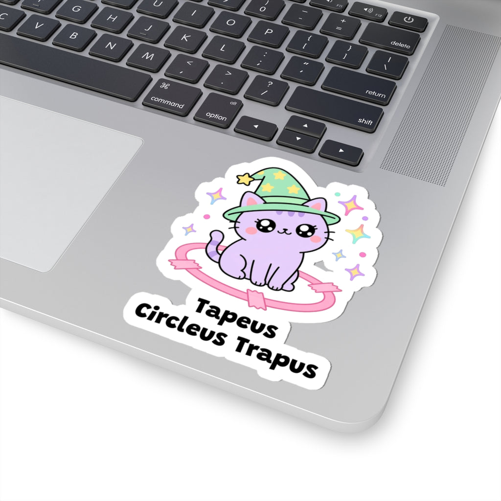 Tapeus Circleus Trapus wizard cat sticker stuck on a silver laptop next to the keyboard