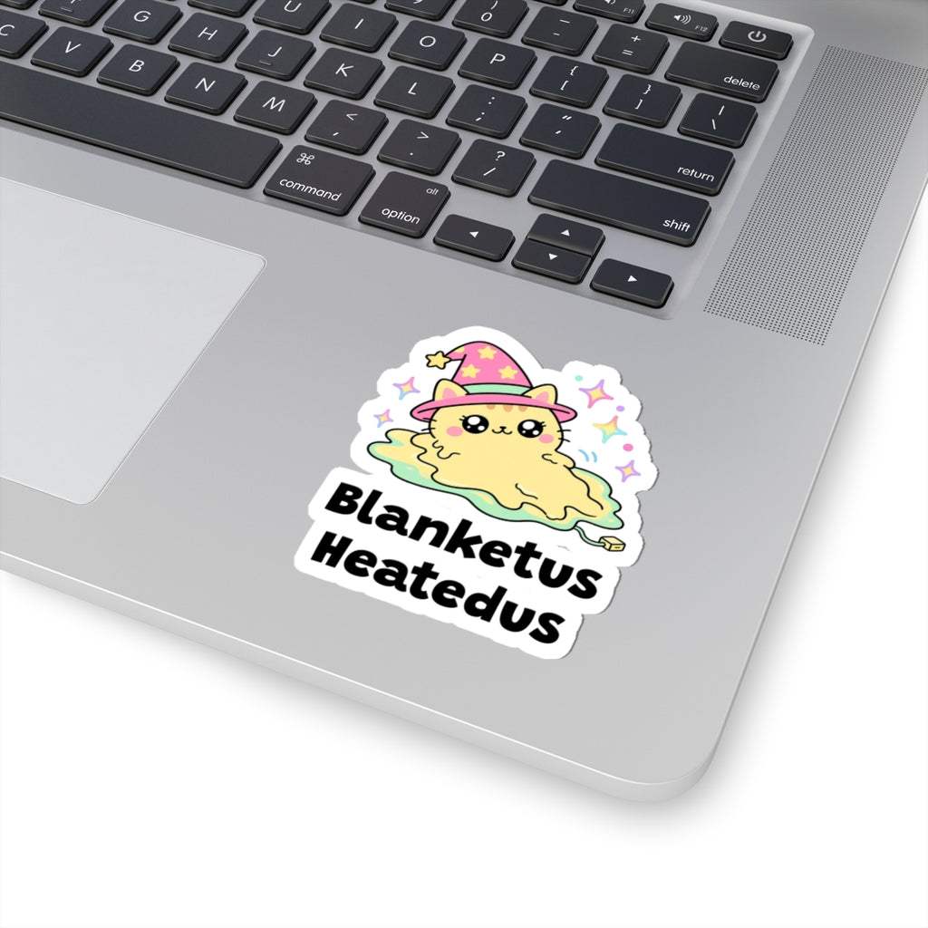 Blanketus Heatedus wizard cat sticker stuck on a silver laptop next to the keyboard