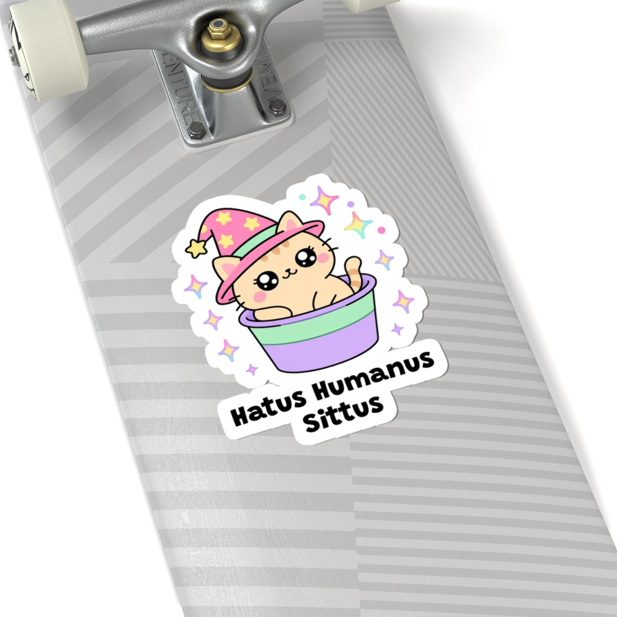 Hatus Humanus Sittus wizard cat sticker on a grey skateboard deck near the truck