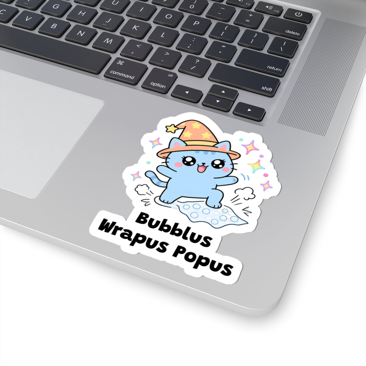 Bubblus Wrapus Popus wizard cat sticker stuck on a silver laptop next to the keyboard