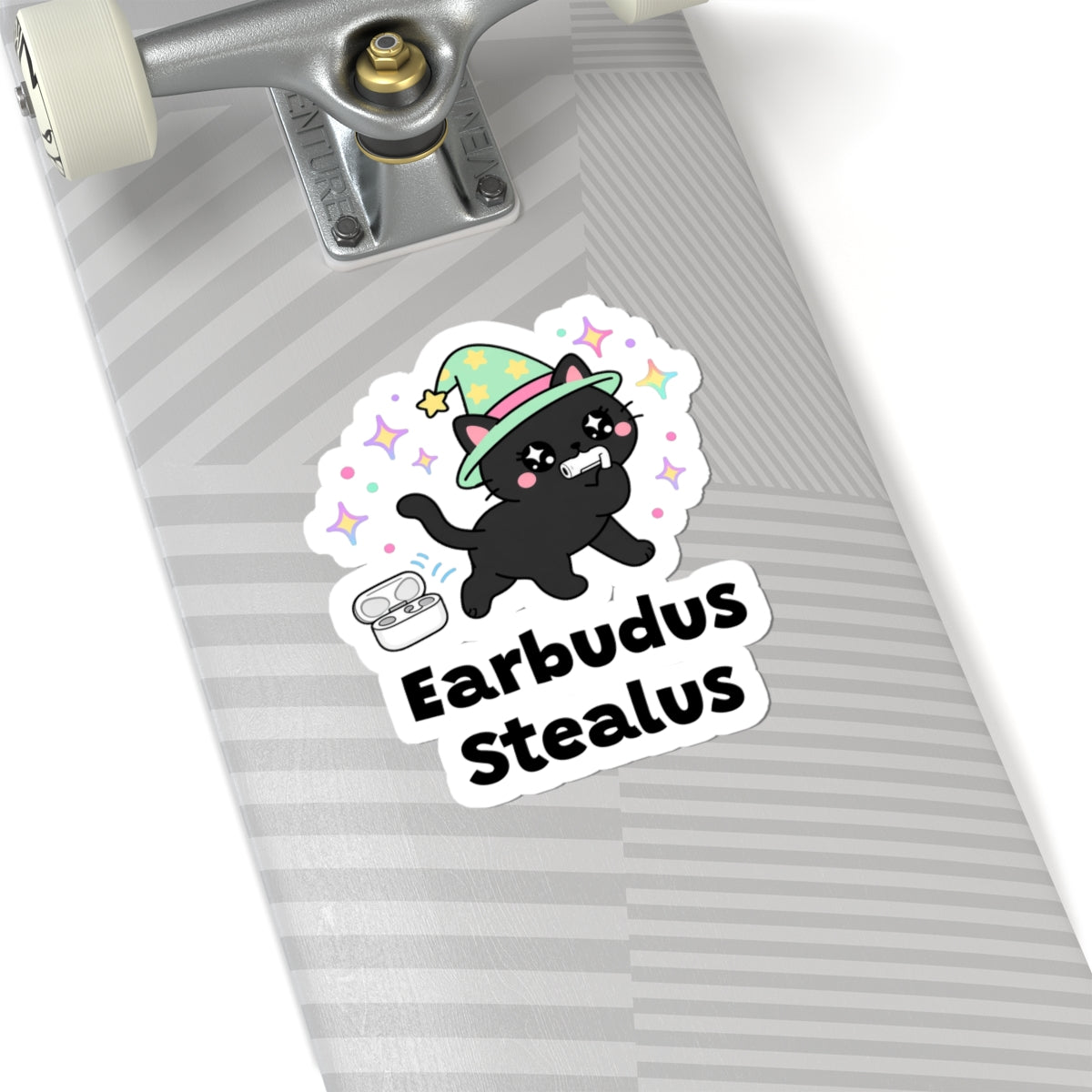 Earbudus Stealus wizard cat sticker on a grey skateboard deck near the truck