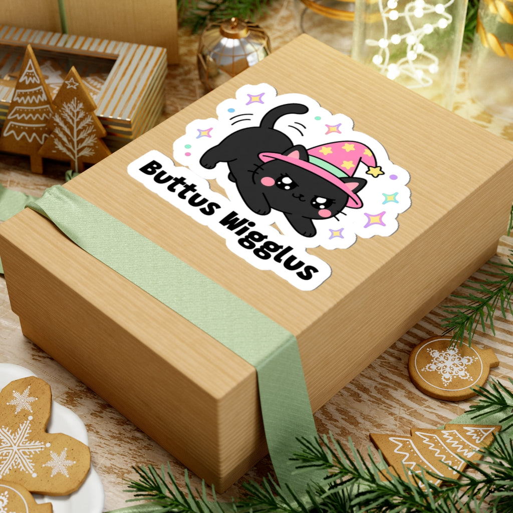 Buttus Wigglus wizard cat sticker on a kraft gift box with a green ribbon and holiday cookies