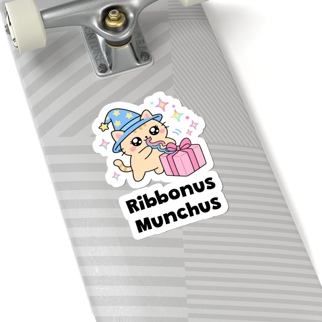 Ribbonus Munchus wizard cat sticker on a grey skateboard deck near the truck