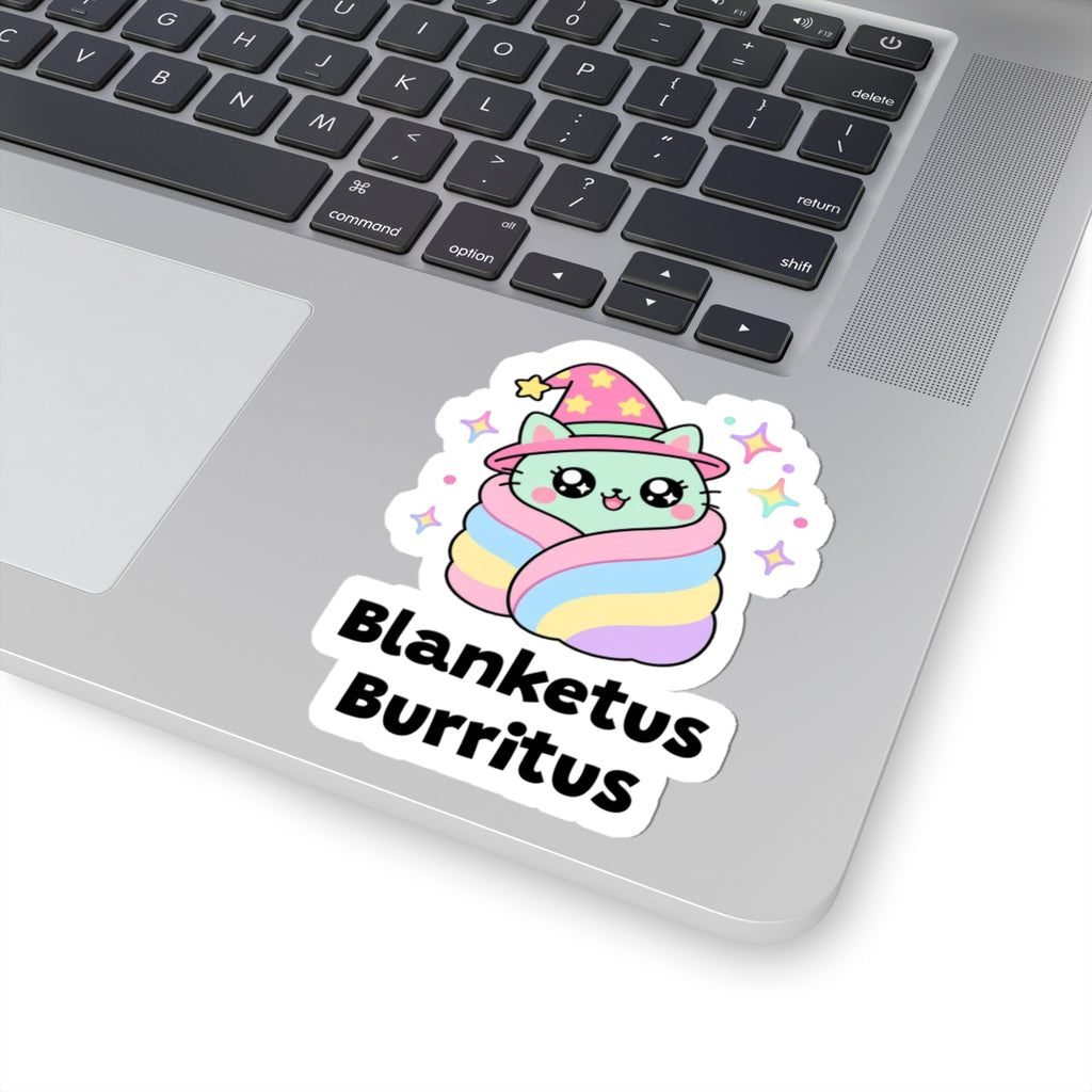 Blanketus Burritus wizard cat sticker stuck on a silver laptop next to the keyboard