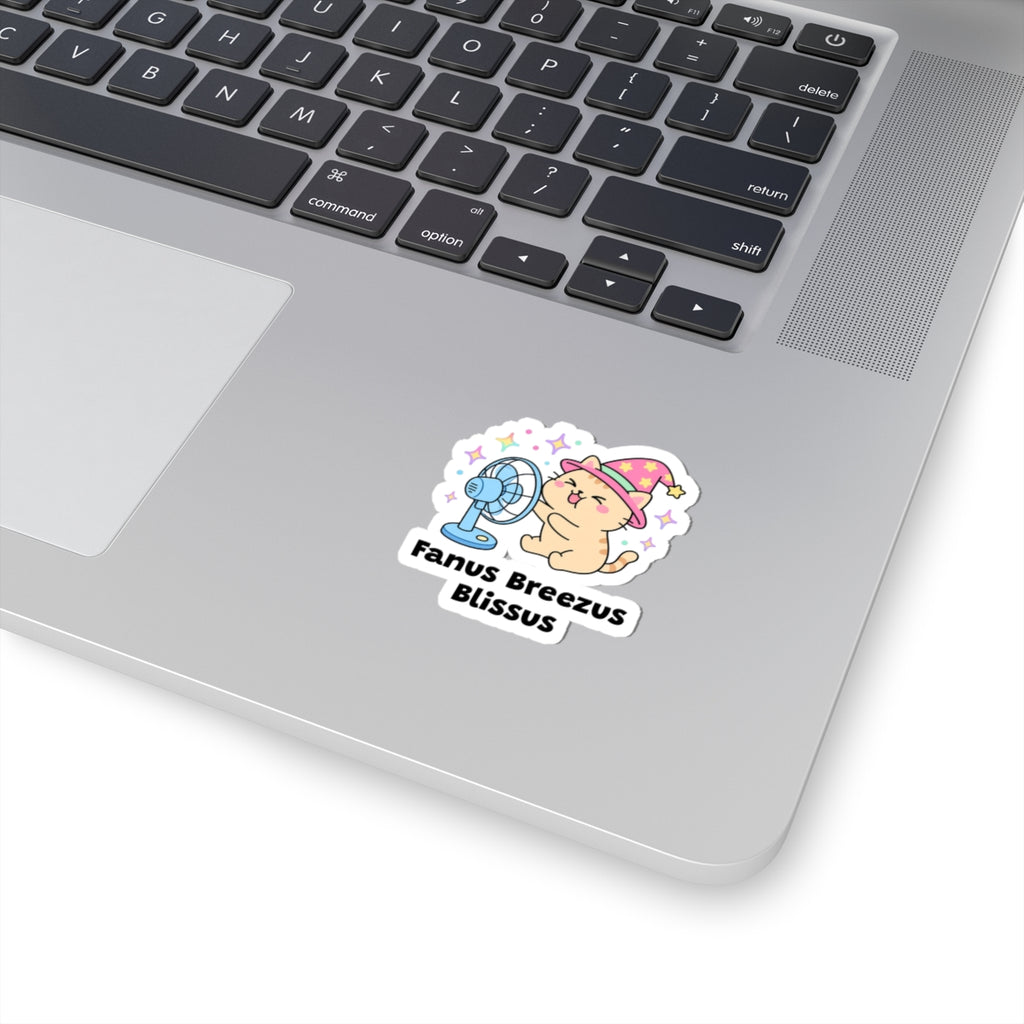 Fanus Breezus Blissus wizard cat sticker stuck on a silver laptop next to the keyboard