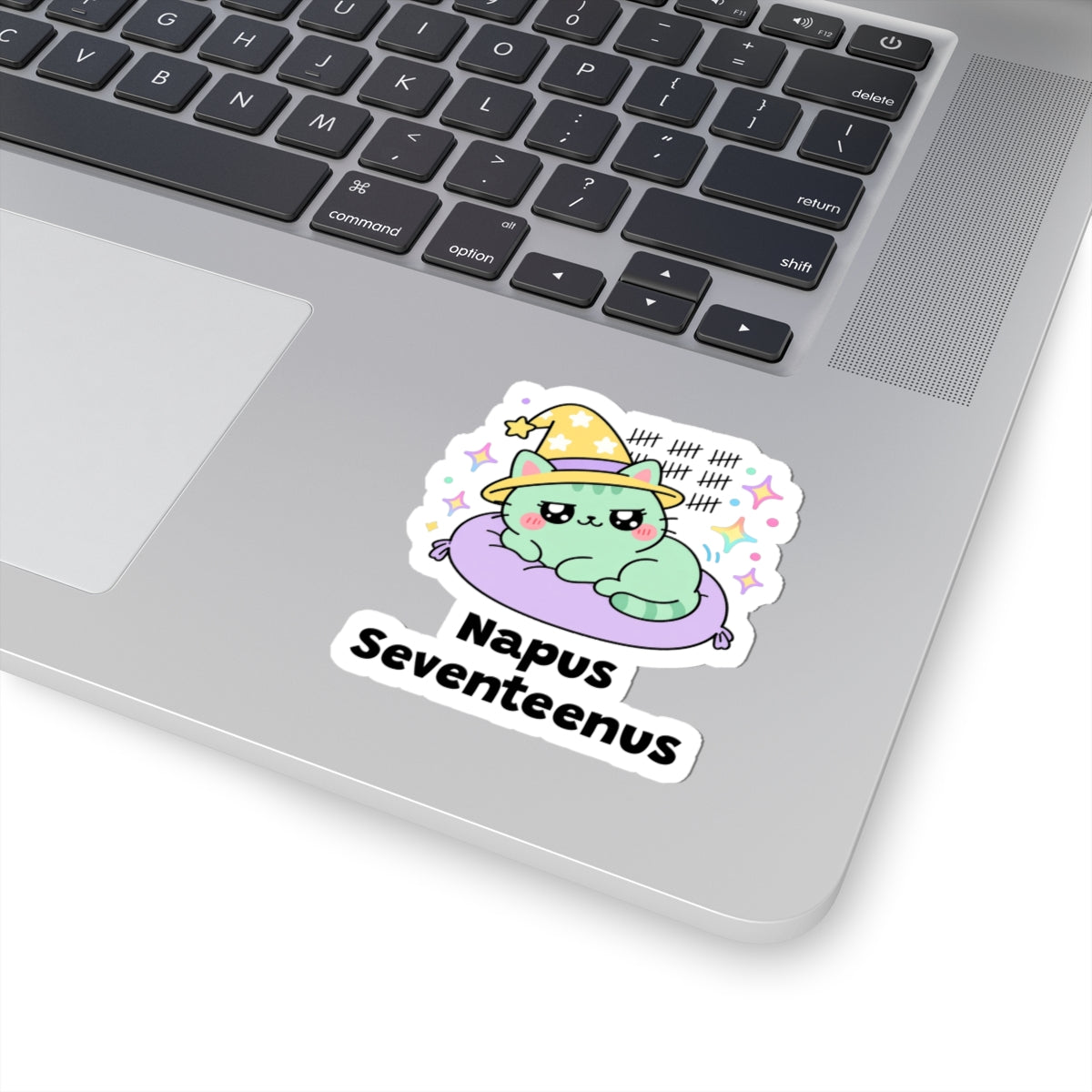 Napus Seventeenus wizard cat sticker stuck on a silver laptop next to the keyboard