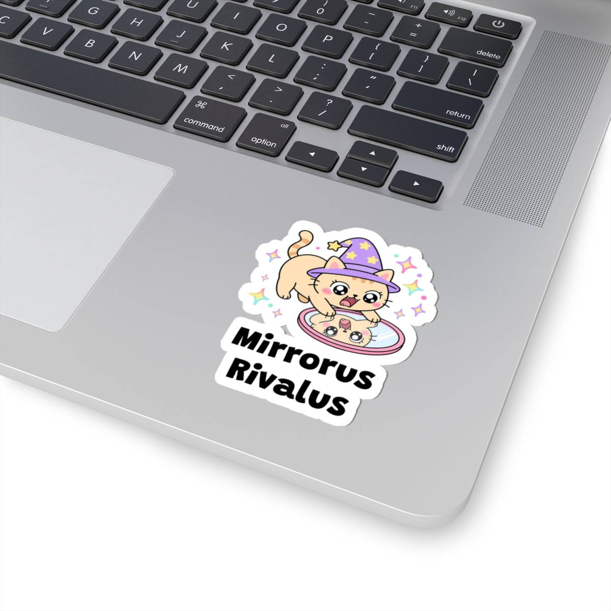 Mirrorus Rivalus wizard cat sticker stuck on a silver laptop next to the keyboard