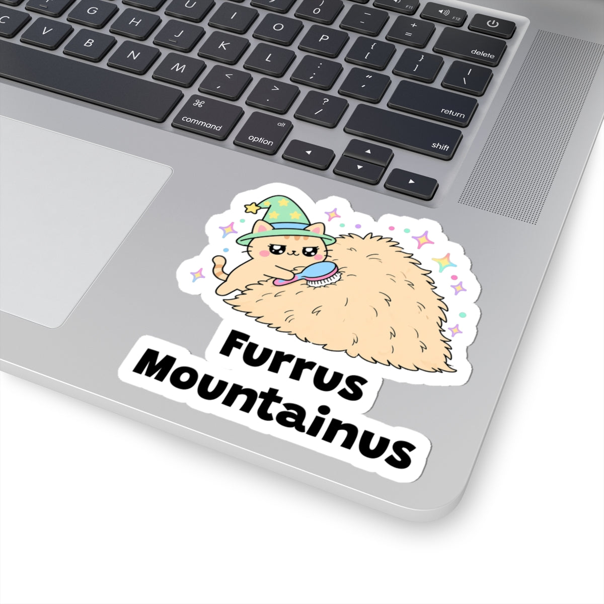 Furrus Mountainus wizard cat sticker stuck on a silver laptop next to the keyboard