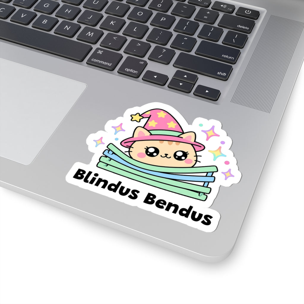 Blindus Bendus wizard cat sticker stuck on a silver laptop next to the keyboard