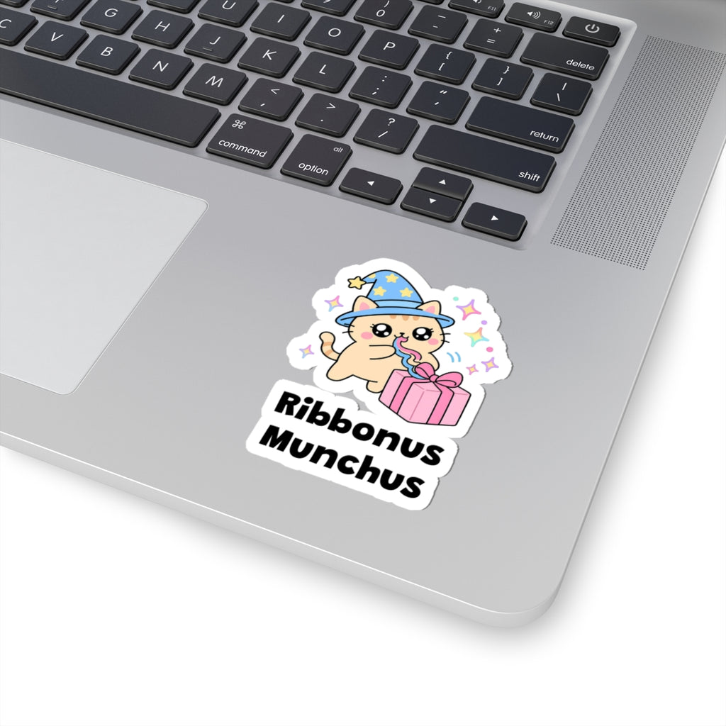 Ribbonus Munchus wizard cat sticker stuck on a silver laptop next to the keyboard