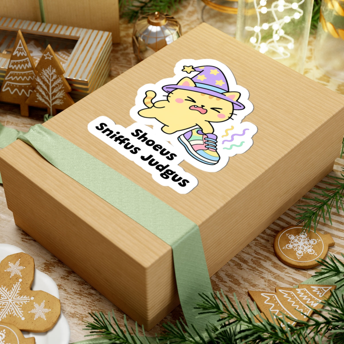 Shoeus Sniffus Judgus wizard cat sticker on a kraft gift box with a green ribbon and holiday cookies