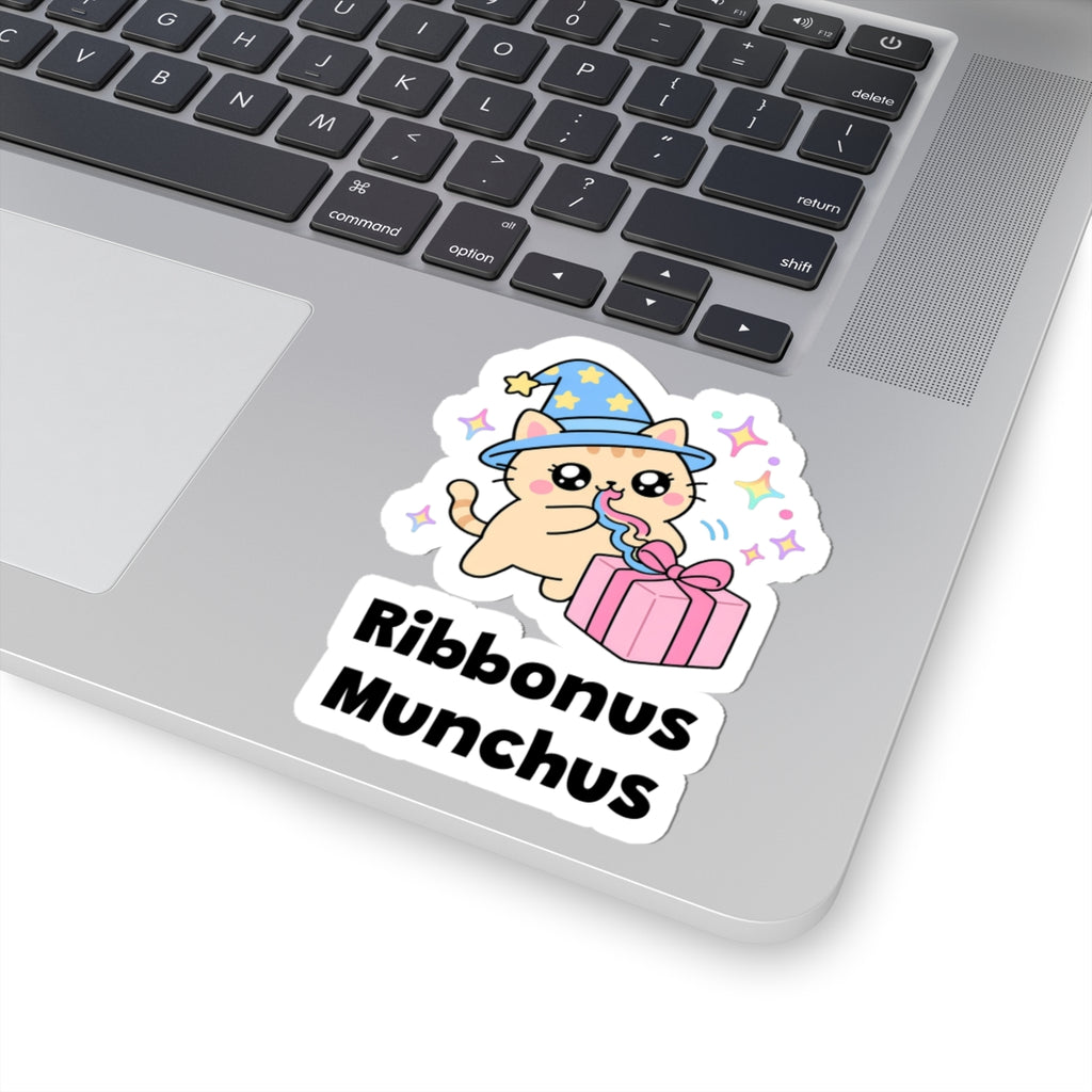 Ribbonus Munchus wizard cat sticker stuck on a silver laptop next to the keyboard