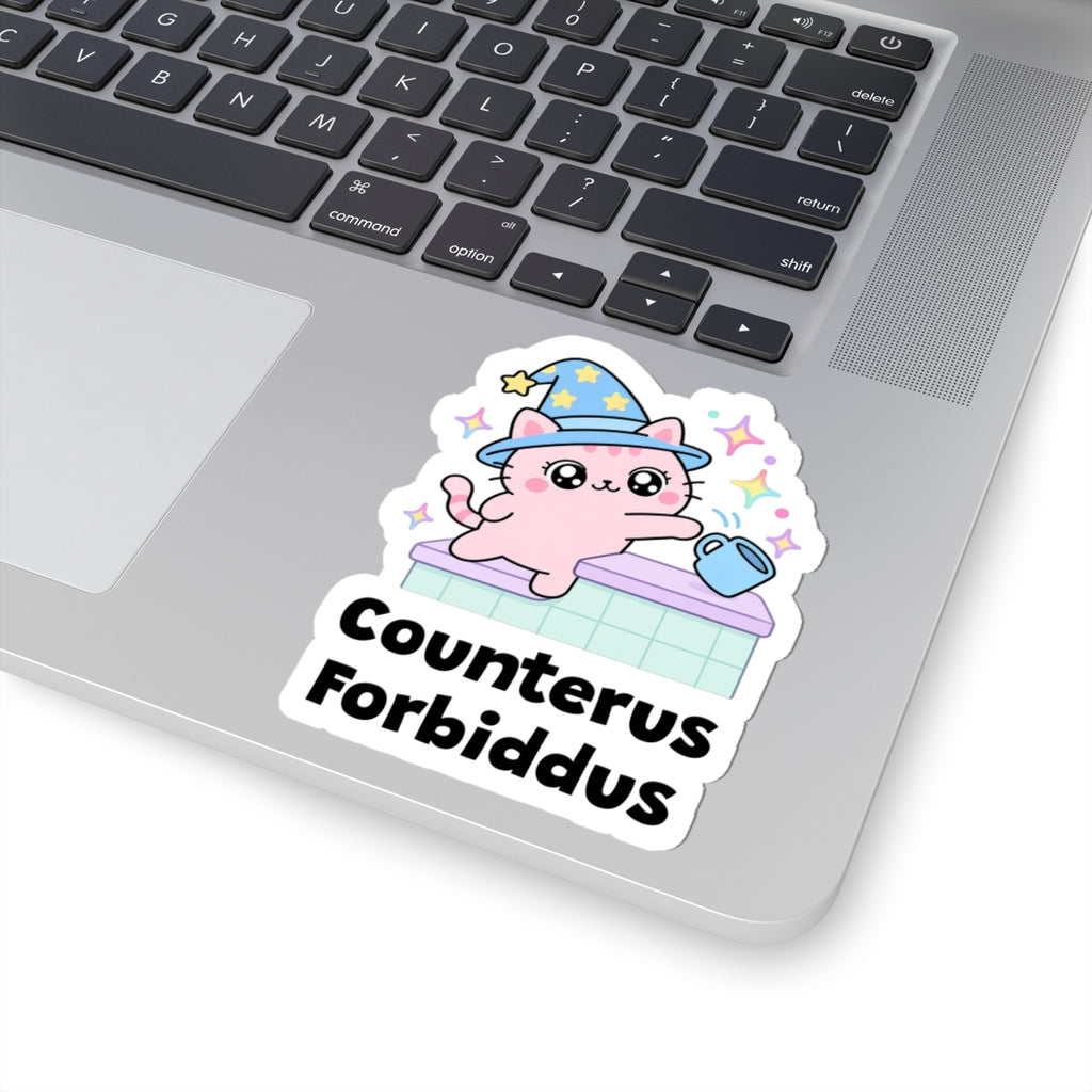 Counterus Forbiddus wizard cat sticker stuck on a silver laptop next to the keyboard