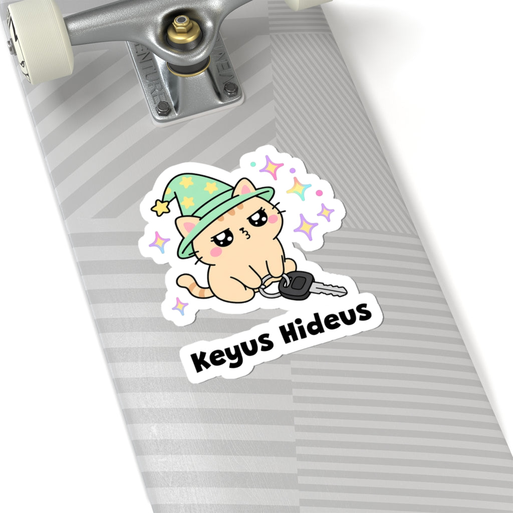 Keyus Hideus wizard cat sticker on a grey skateboard deck near the truck