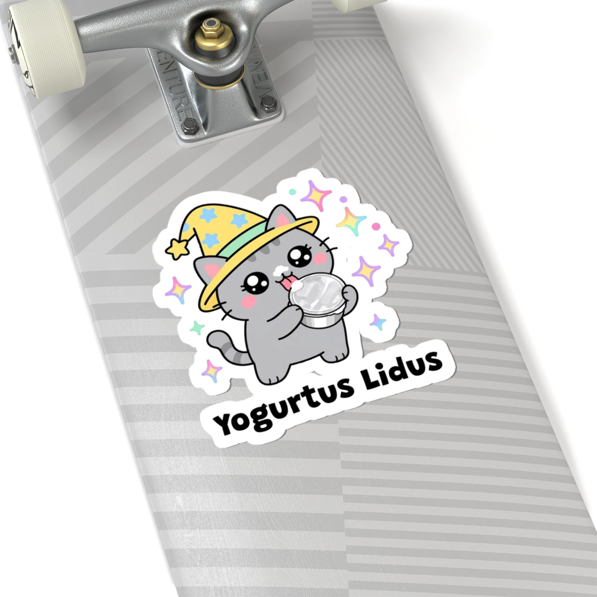 Yogurtus Lidus wizard cat sticker on a grey skateboard deck near the truck