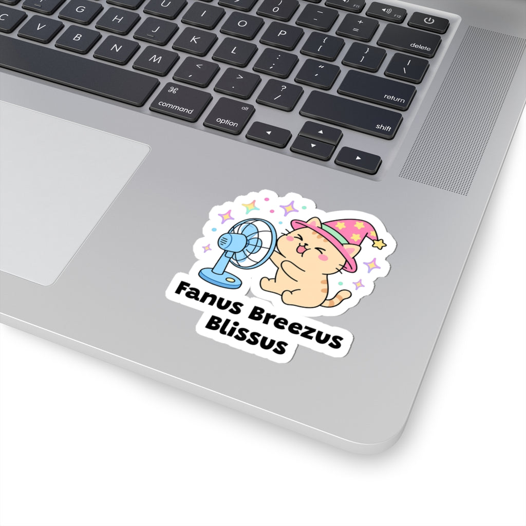 Fanus Breezus Blissus wizard cat sticker stuck on a silver laptop next to the keyboard