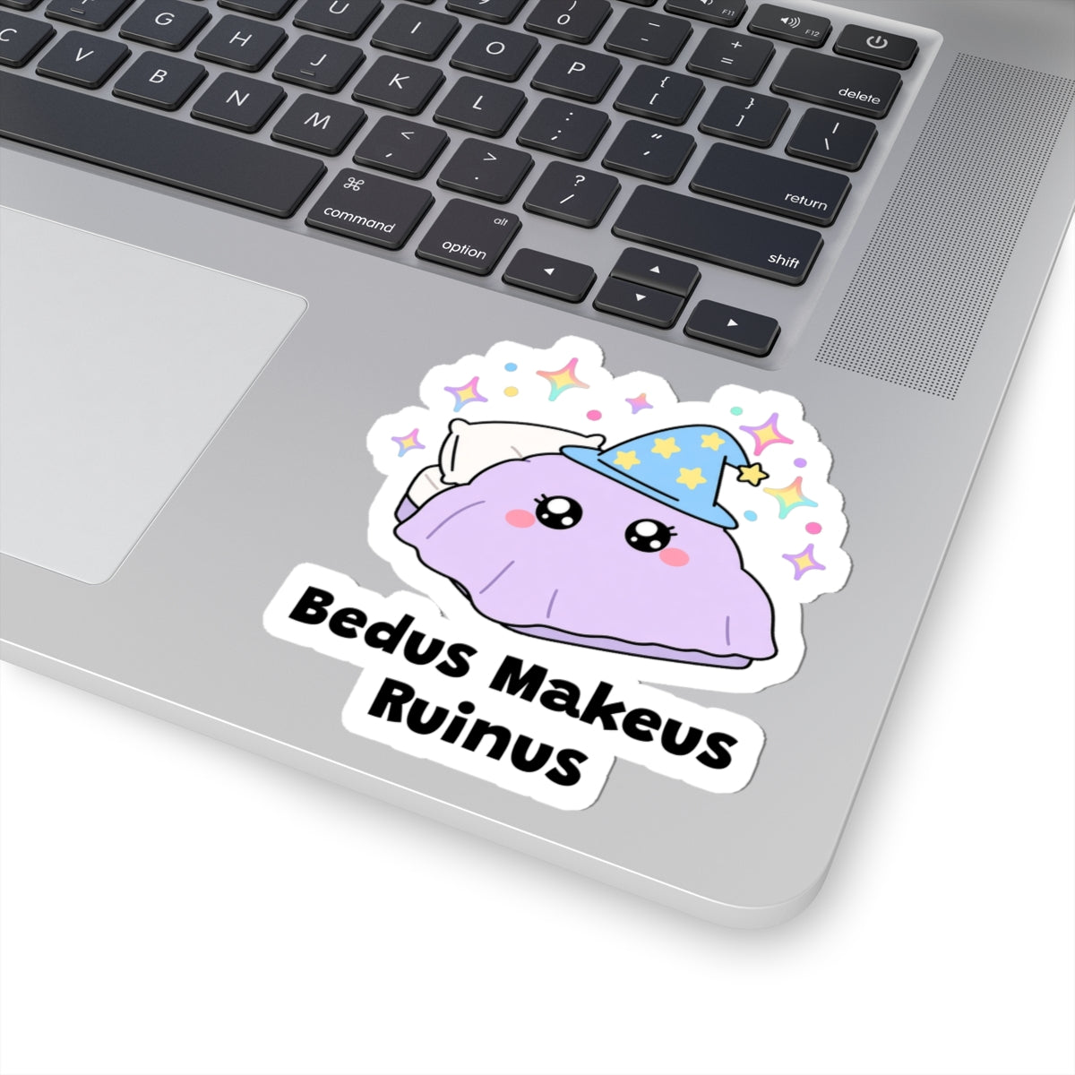 Bedus Makeus Ruinus wizard cat sticker stuck on a silver laptop next to the keyboard