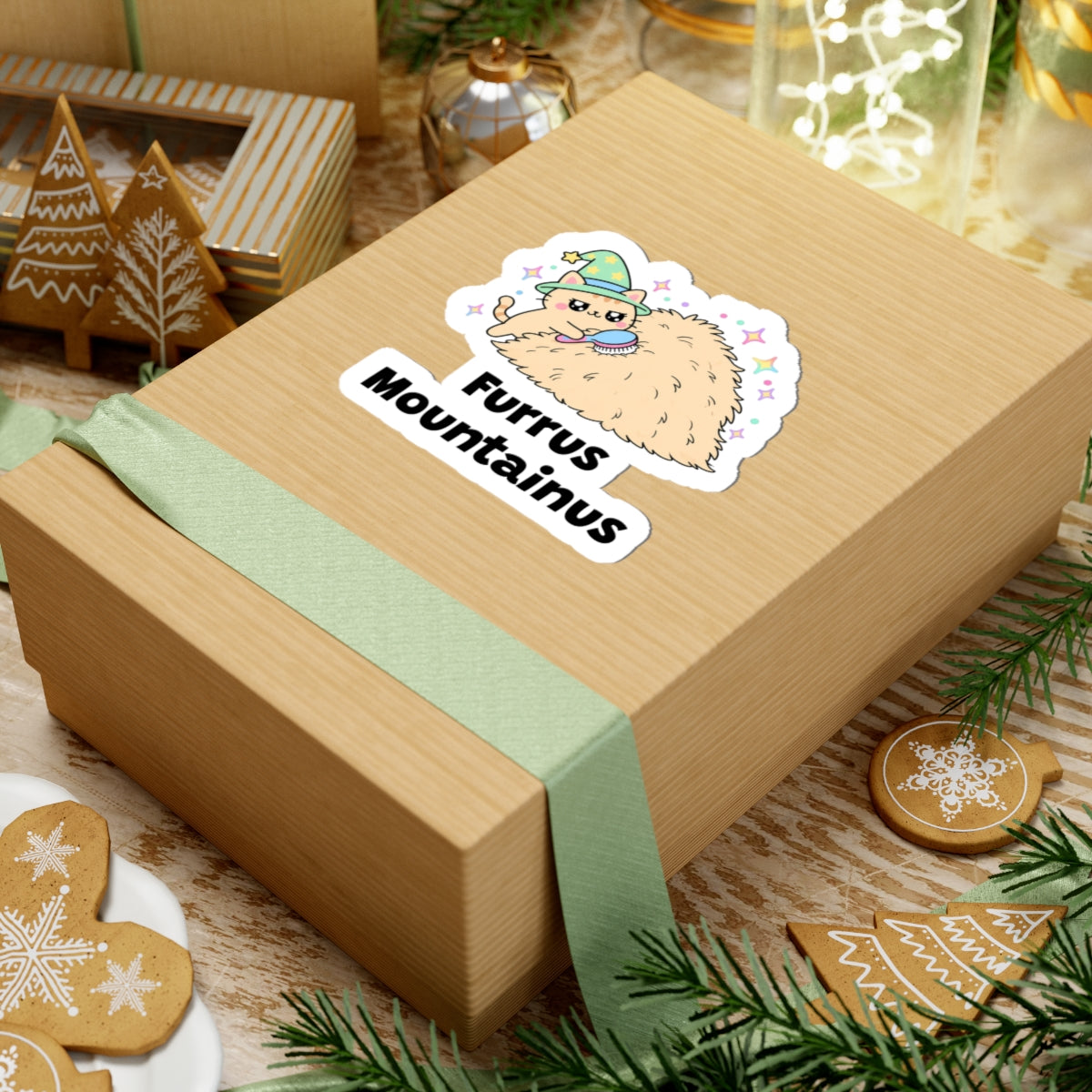 Furrus Mountainus wizard cat sticker on a kraft gift box with a green ribbon and holiday cookies