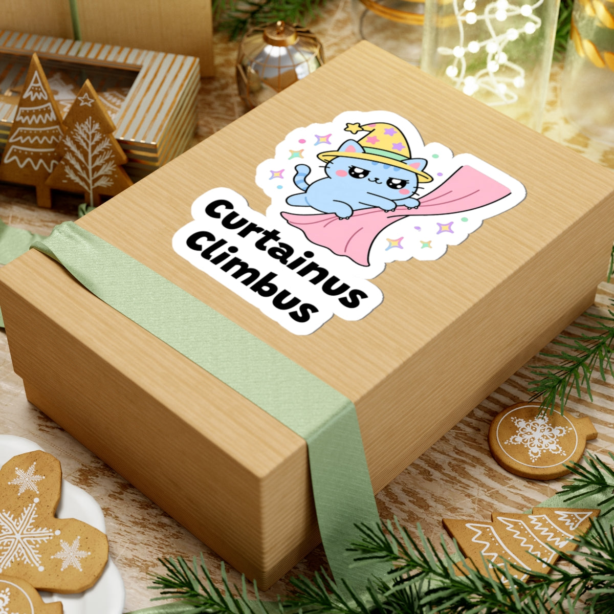 Curtainus Climbus wizard cat sticker on a kraft gift box with a green ribbon and holiday cookies