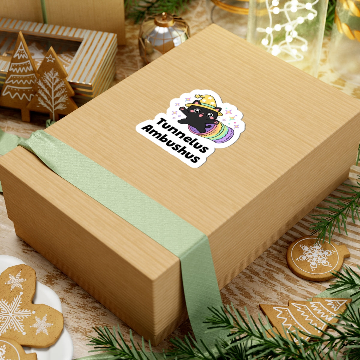 Tunnelus Ambushus wizard cat sticker on a kraft gift box with a green ribbon and holiday cookies