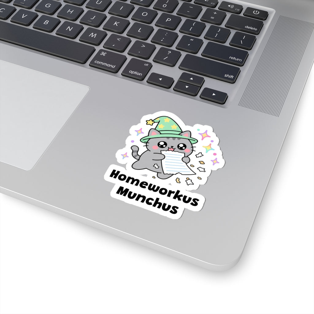 Homeworkus Munchus wizard cat sticker stuck on a silver laptop next to the keyboard