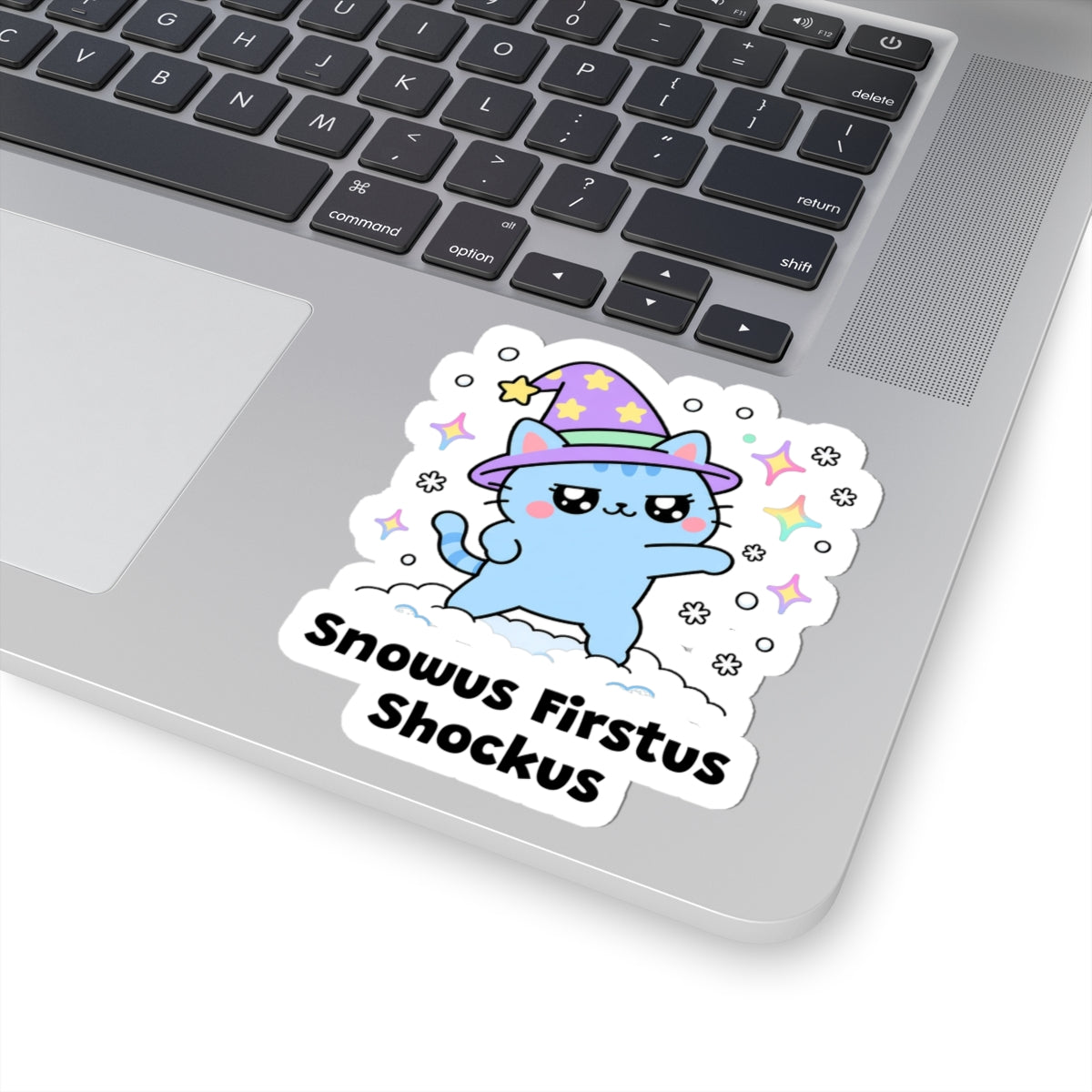 Snowus Firstus Shockus wizard cat sticker stuck on a silver laptop next to the keyboard
