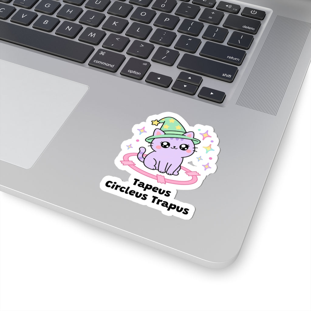 Tapeus Circleus Trapus wizard cat sticker stuck on a silver laptop next to the keyboard