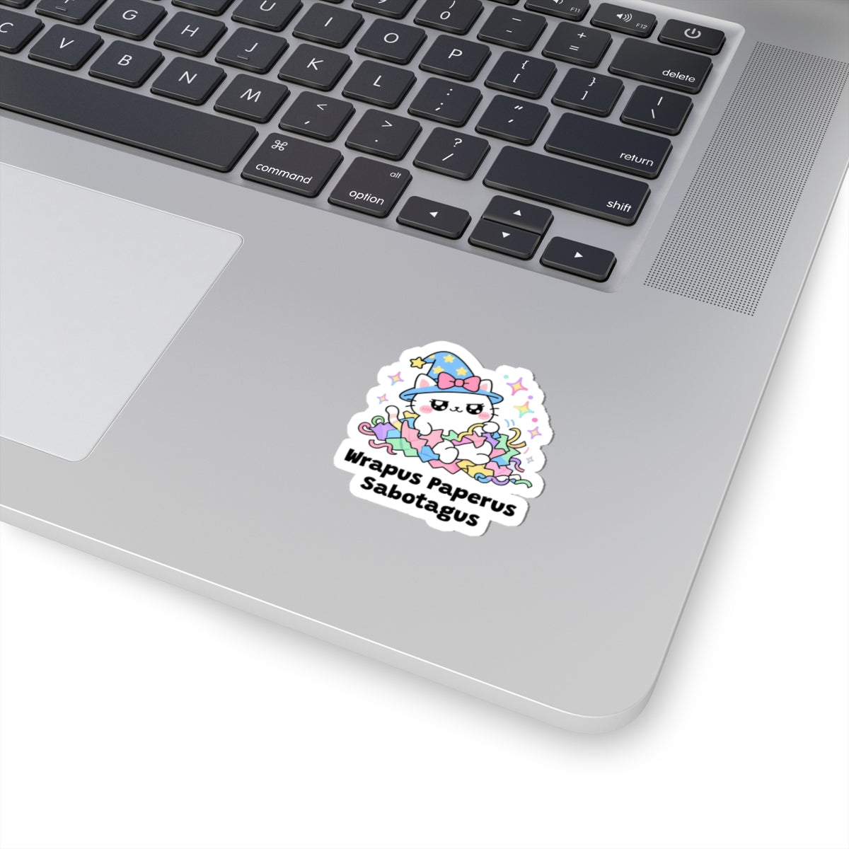 Wrapus Paperus Sabotagus wizard cat sticker stuck on a silver laptop next to the keyboard