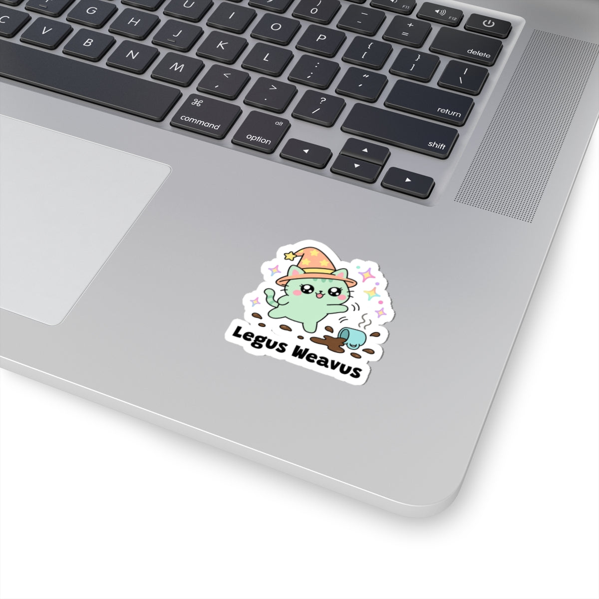 Legus Weavus wizard cat sticker stuck on a silver laptop next to the keyboard