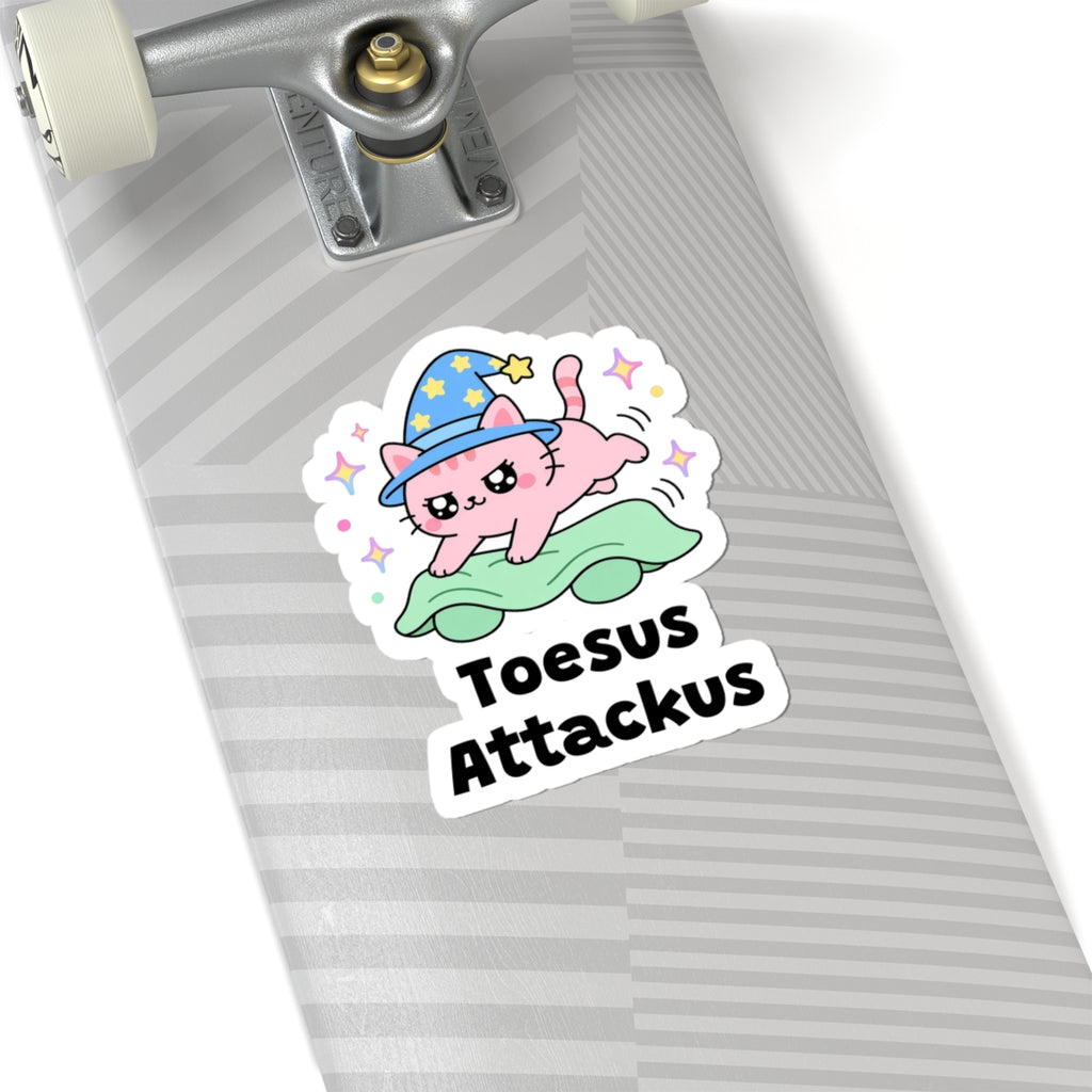 Toesus Attackus wizard cat sticker on a grey skateboard deck near the truck