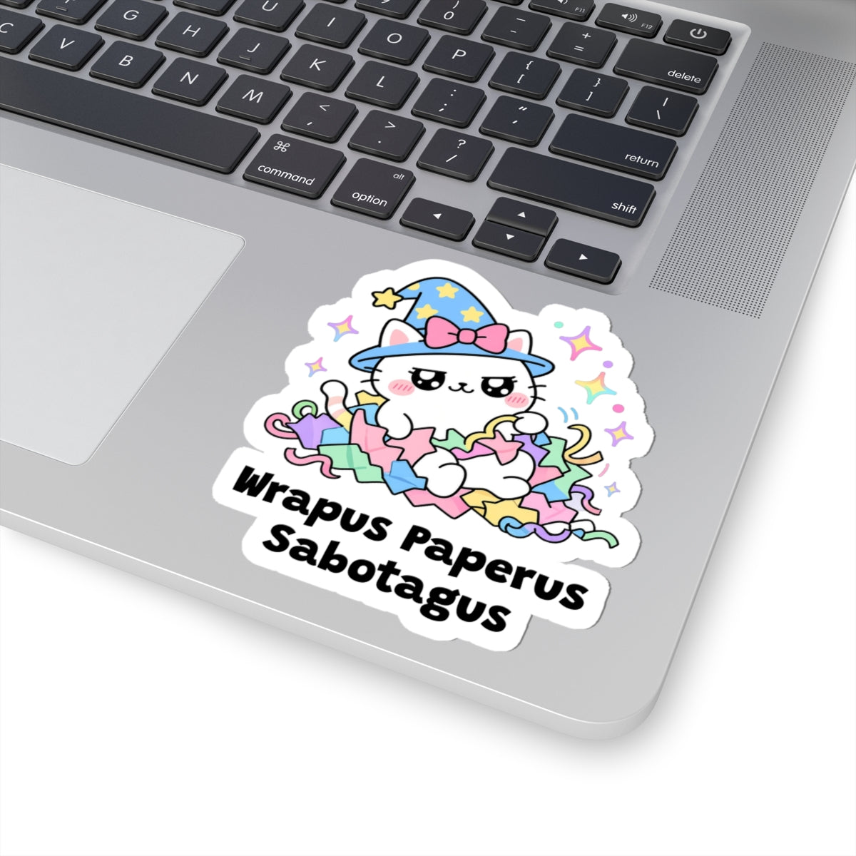 Wrapus Paperus Sabotagus wizard cat sticker stuck on a silver laptop next to the keyboard