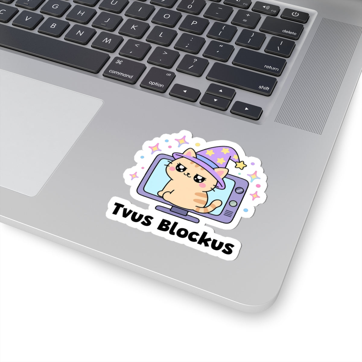 Tvus Blockus wizard cat sticker stuck on a silver laptop next to the keyboard