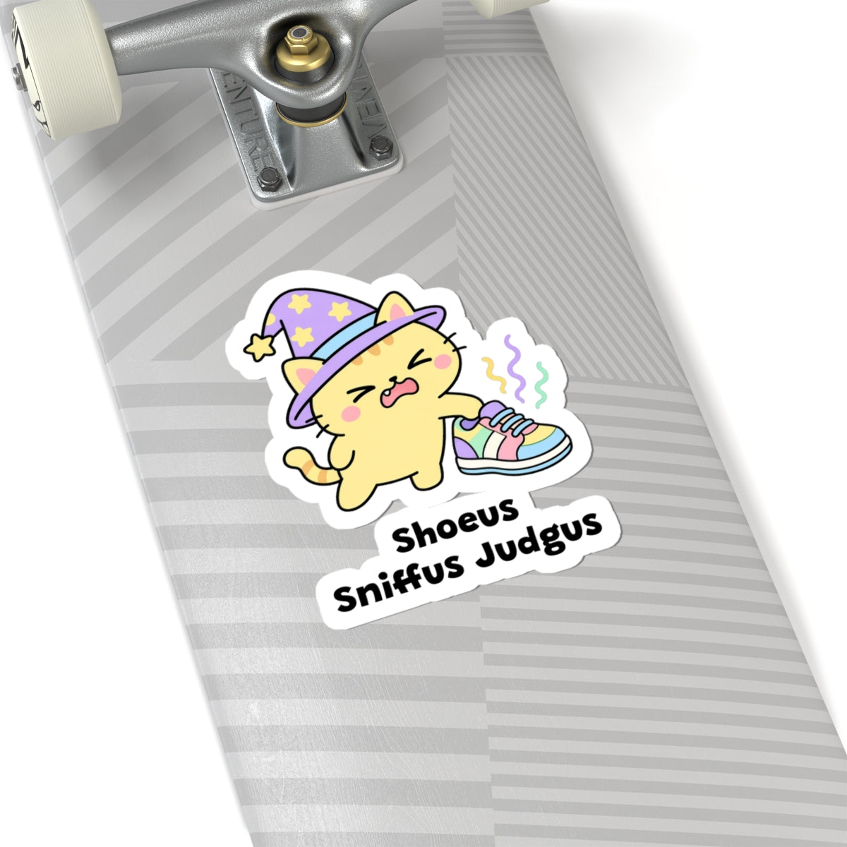 Shoeus Sniffus Judgus wizard cat sticker on a grey skateboard deck near the truck