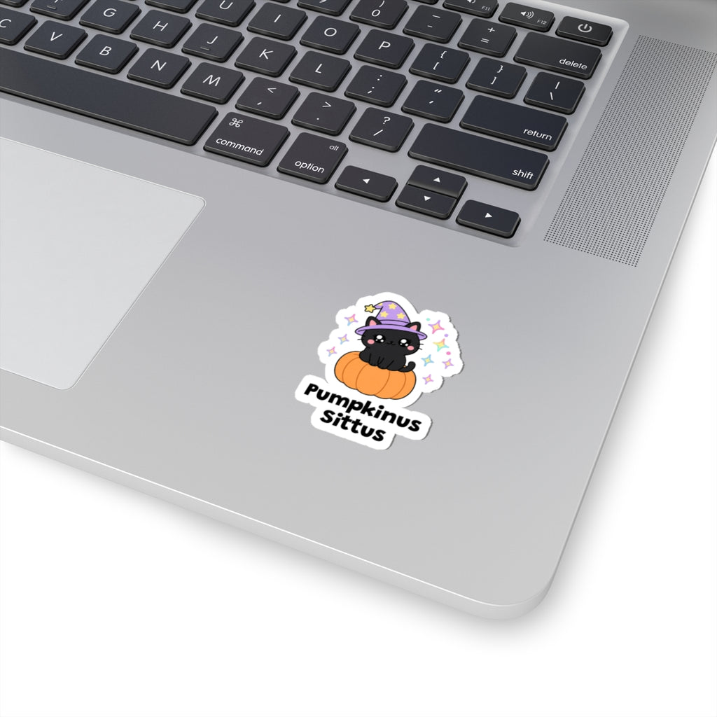 Pumpkinus Sittus wizard cat sticker stuck on a silver laptop next to the keyboard