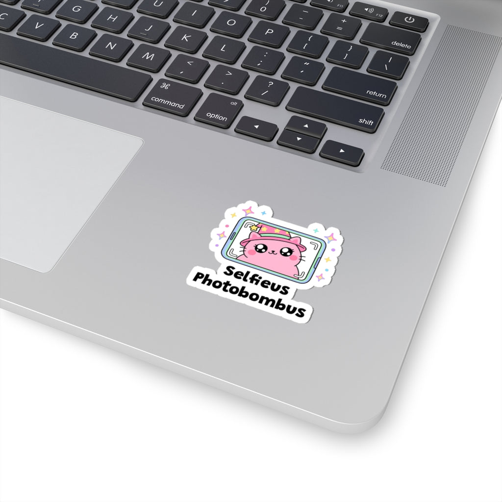 Selfieus Photobombus wizard cat sticker stuck on a silver laptop next to the keyboard