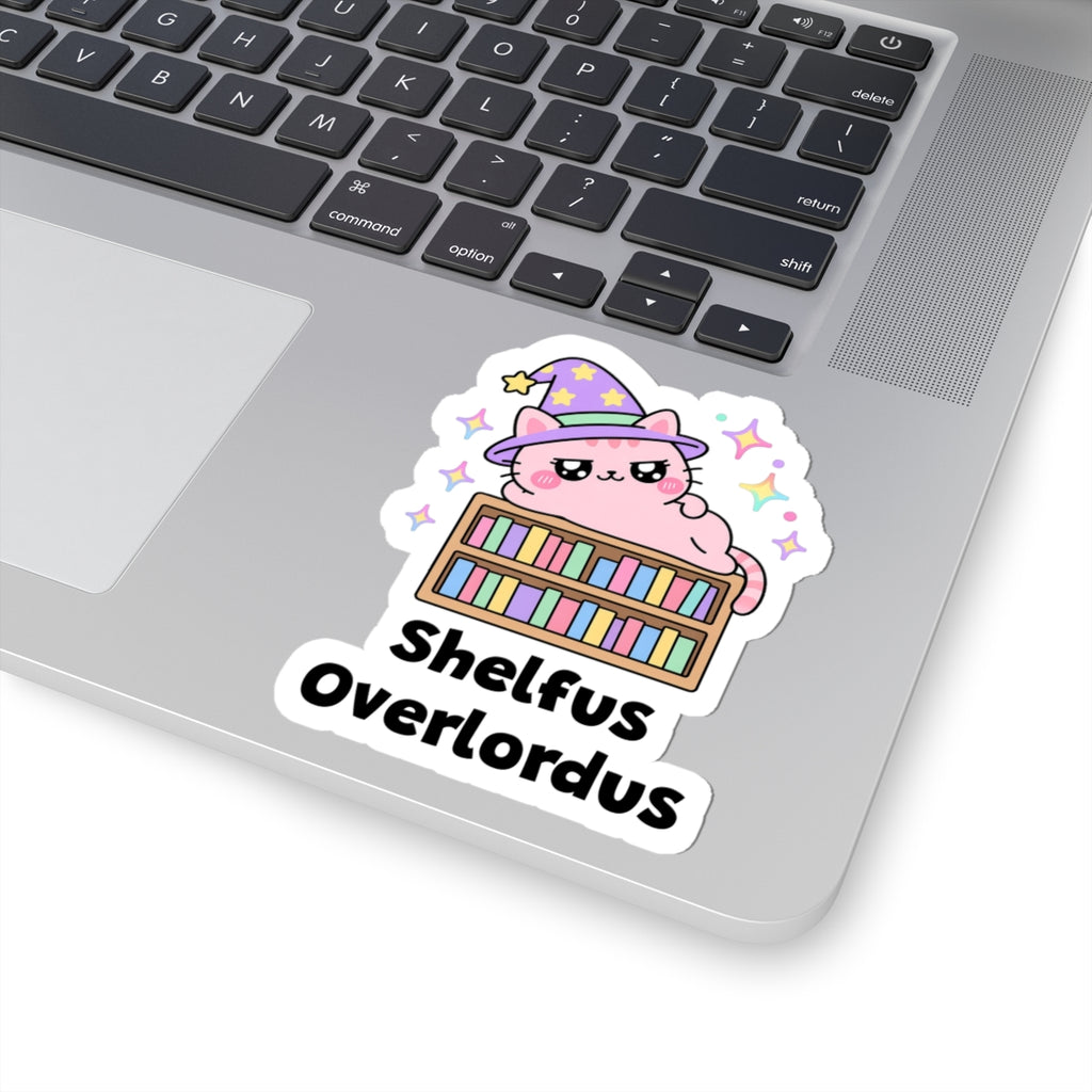 Shelfus Overlordus wizard cat sticker stuck on a silver laptop next to the keyboard