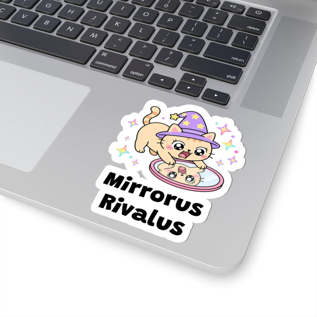 Mirrorus Rivalus wizard cat sticker stuck on a silver laptop next to the keyboard