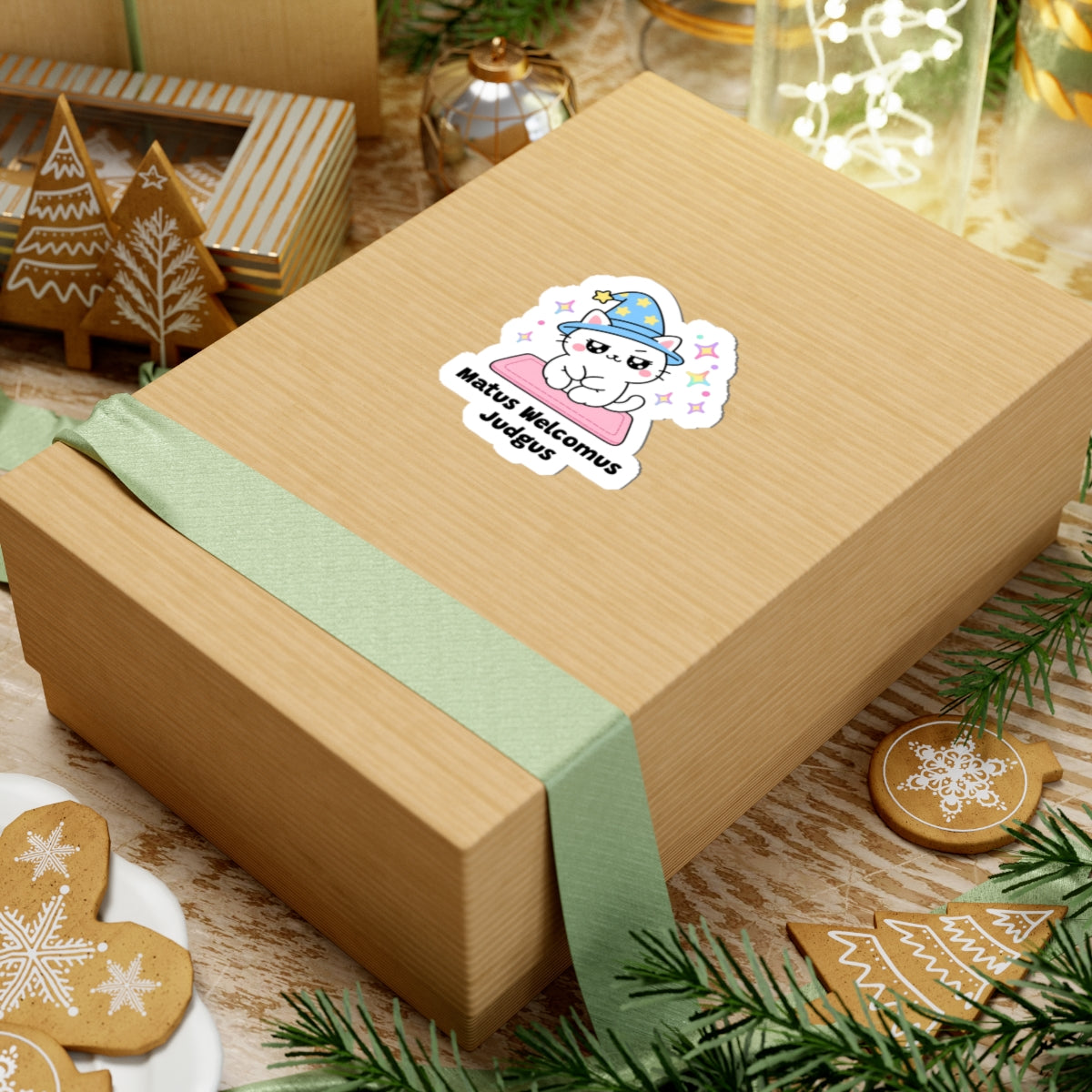 Matus Welcomus Judgus wizard cat sticker on a kraft gift box with a green ribbon and holiday cookies