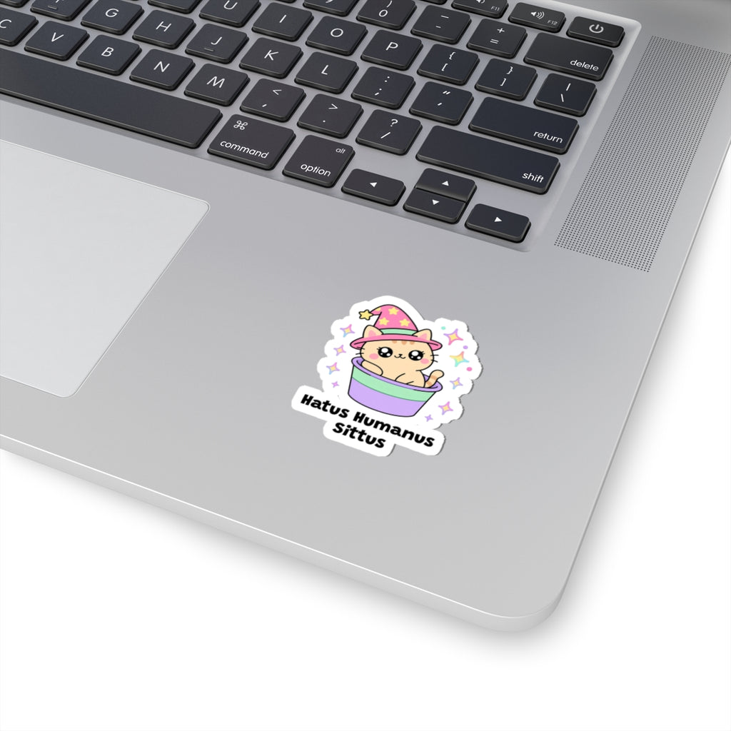 Hatus Humanus Sittus wizard cat sticker stuck on a silver laptop next to the keyboard