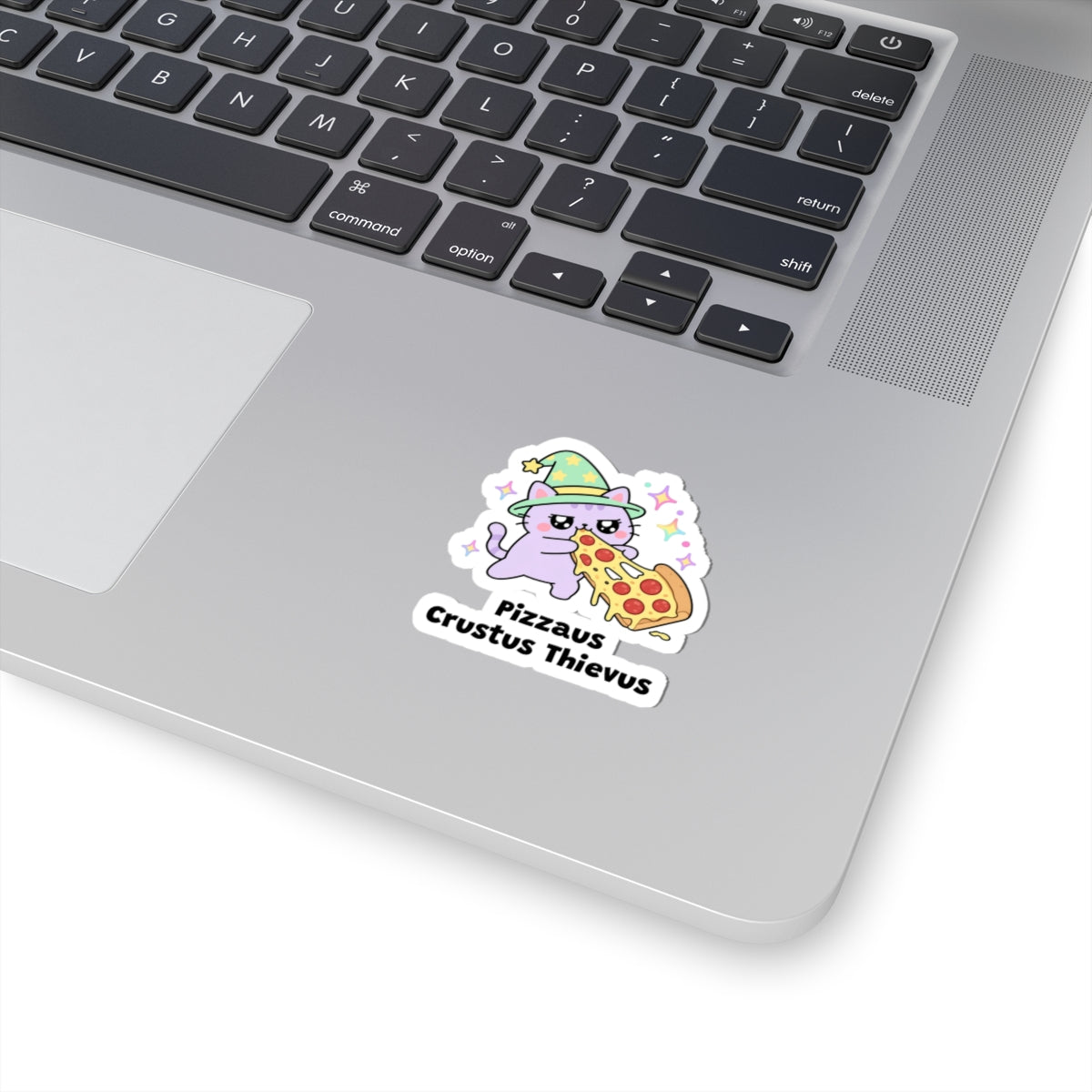 Pizzaus Crustus Thievus wizard cat sticker stuck on a silver laptop next to the keyboard