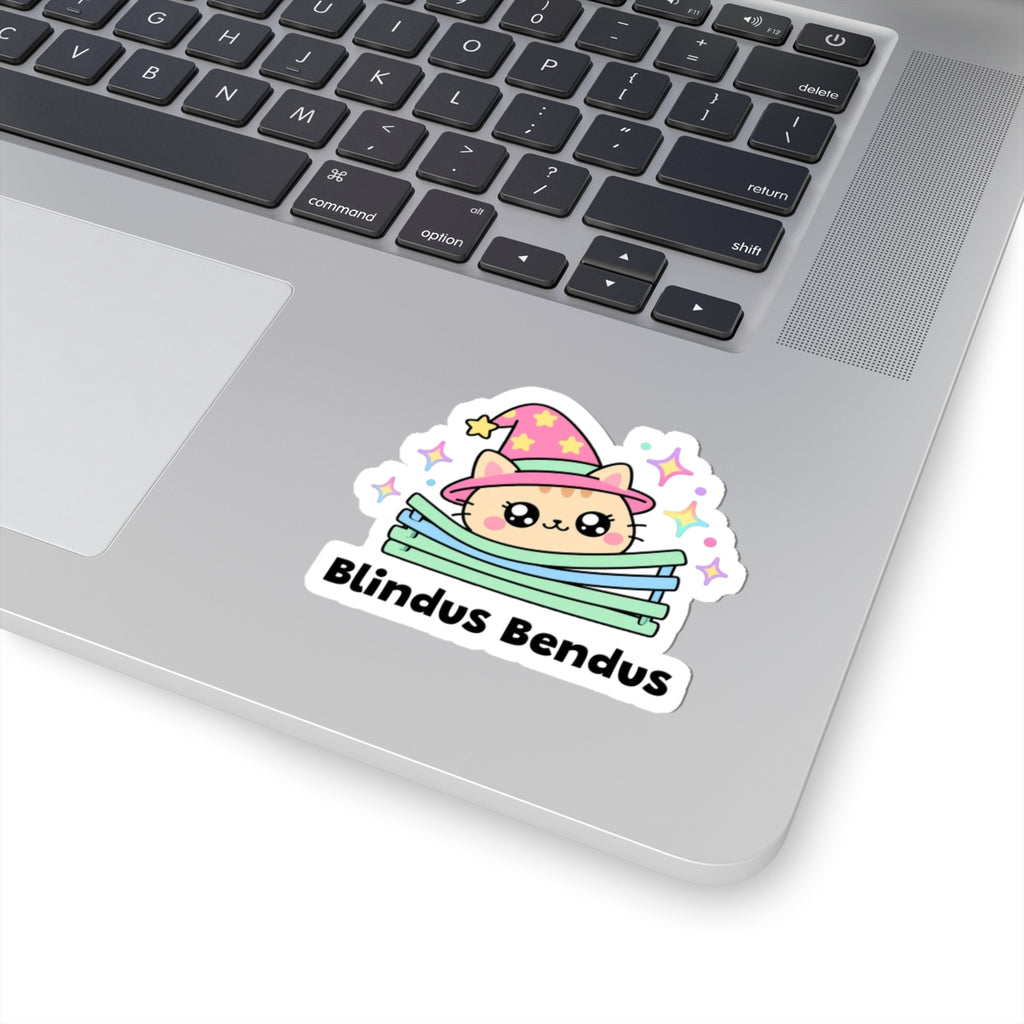 Blindus Bendus wizard cat sticker stuck on a silver laptop next to the keyboard