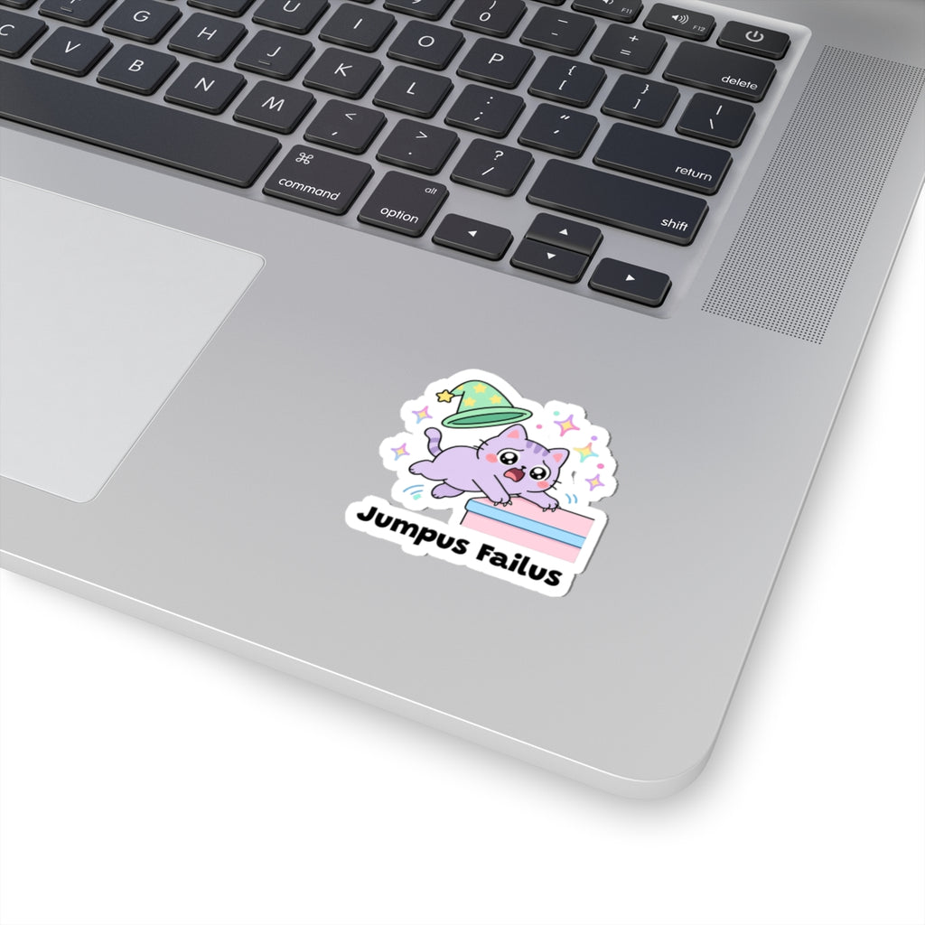 Jumpus Failus wizard cat sticker stuck on a silver laptop next to the keyboard
