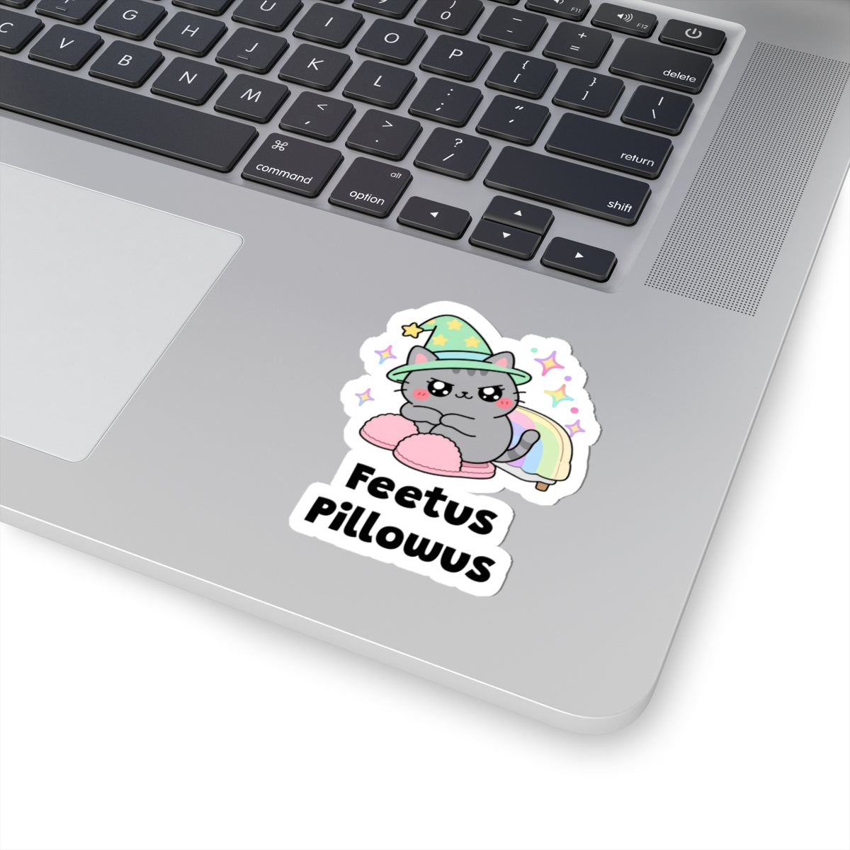 Feetus Pillowus wizard cat sticker stuck on a silver laptop next to the keyboard
